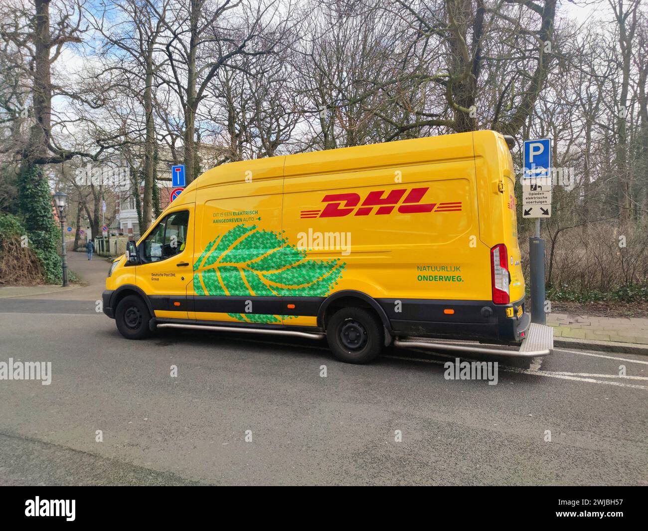 Elektrischer Lieferwagen des Logistikunternehmens DHL in einer Straße in den Haag, Niederlande Stockfoto