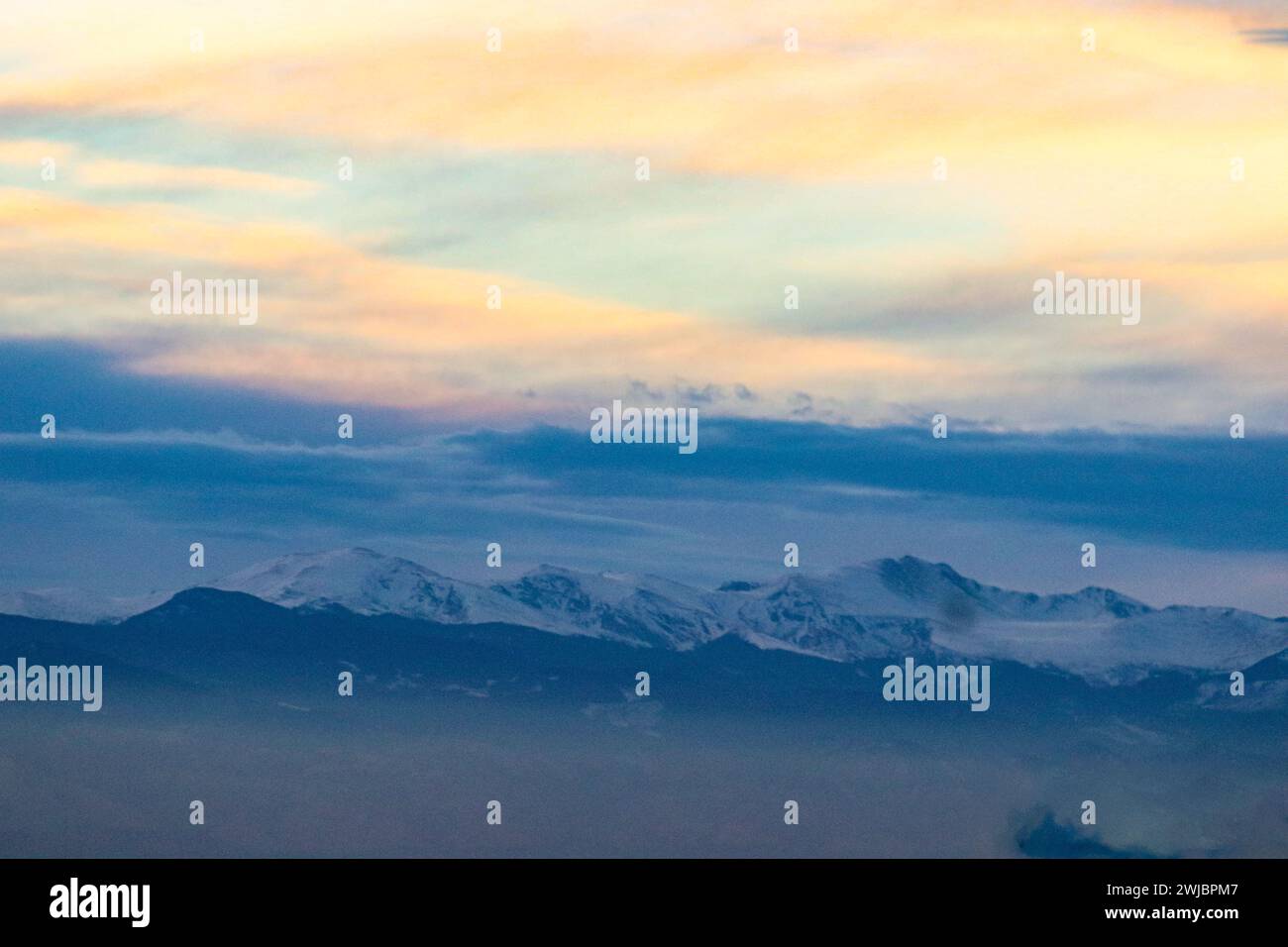 Aus der Vogelperspektive eines Flugzeugs, das über schneebedeckten Berggipfeln schwebt Stockfoto