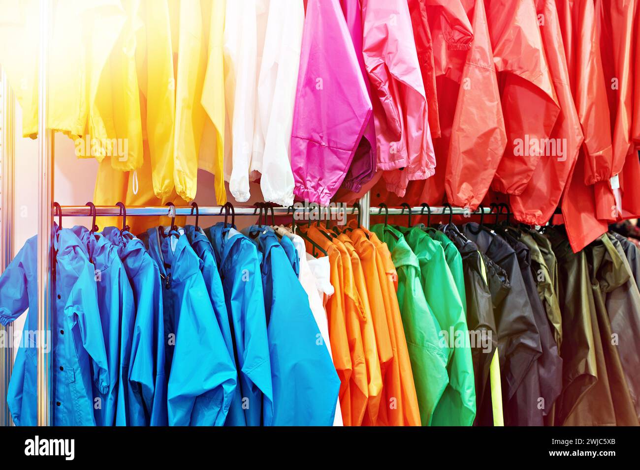 Modische bunte Kleidung auf einem Kleiderbügel in einem Geschäft Stockfoto