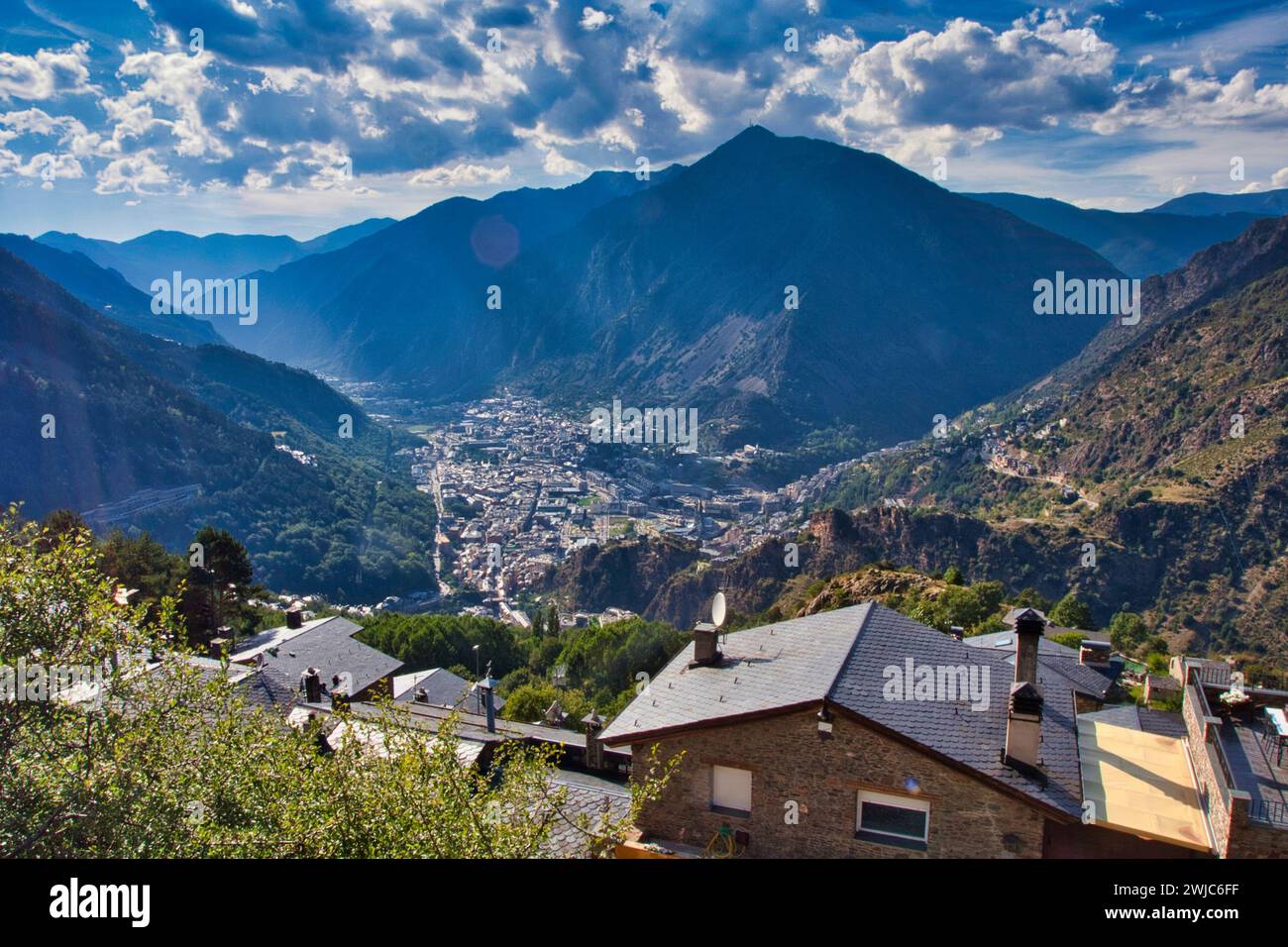 Ein ruhiges Bergdorf, umgeben von ätherischen Wolken und in goldenes Sonnenlicht getaucht Stockfoto