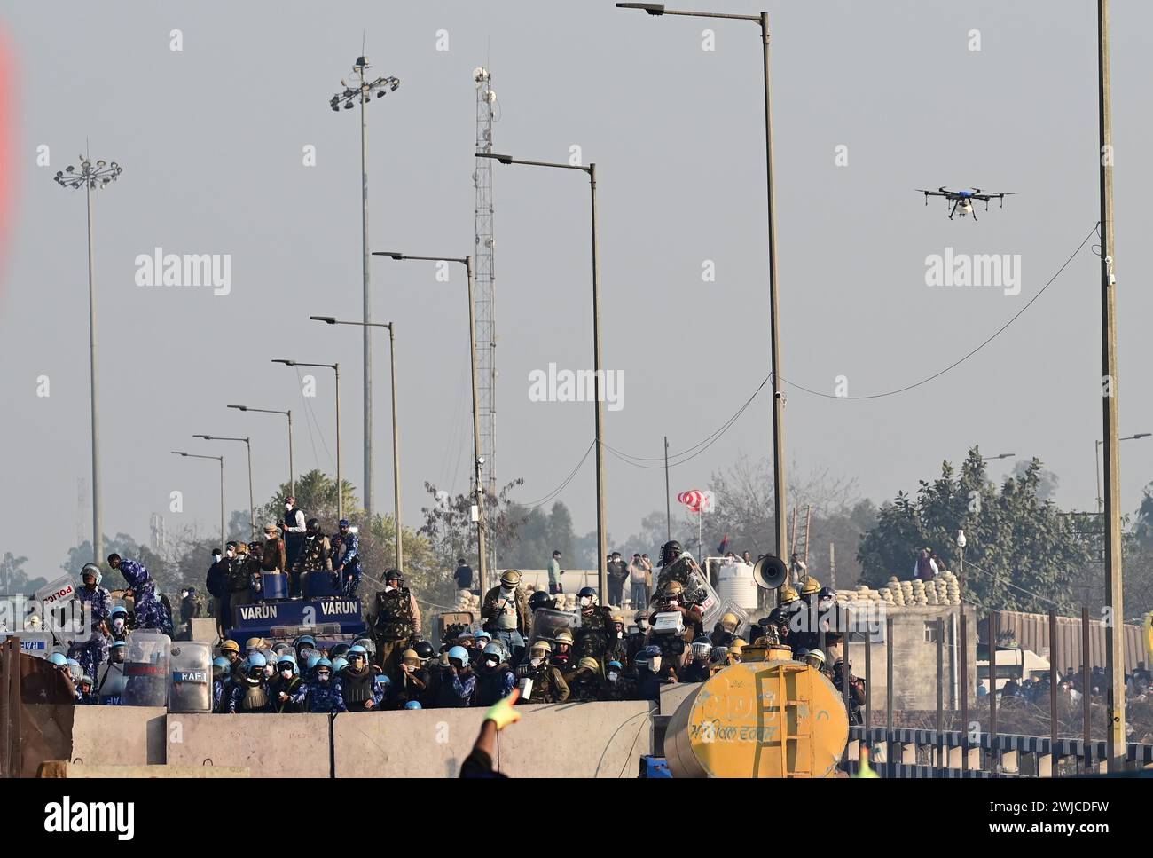 CHANDIGARH, INDIEN – 14. FEBRUAR: Haryana Polizei, Rapid Action Force und Drohne während des Protests der Bauern an der Grenze von Punjab und Haryana in der Nähe von Ambala, am 14. Februar 2024 in Chandigarh, Indien. Die Polizei setzte Tränengas ein, um Tausende von Landwirten, die nach erfolglosen Verhandlungen mit der Regierung Mindestpreise für die Ernte fordern, daran zu hindern, in die Hauptstadt Neu-Delhi vorzudringen. Tränengasgranaten wurden abgefeuert und Wasser aus Tankern auf die protestierenden Bauern gesprüht, die versuchten, die Grenze zu Shambhu zu überqueren. Die Polizei hatte sogar früher am Tag Tränengasgranaten nach di abgefeuert Stockfoto