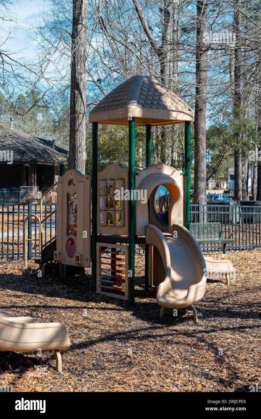 Kinderrutsche und Dschungel-Fitnessstudio oder Kletterhaus auf einem umzäunten Spielplatz in Pike Road Alabama, USA. Stockfoto