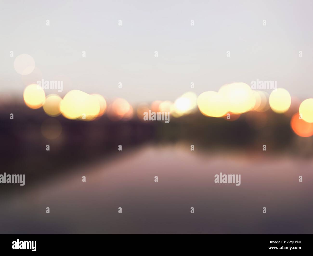 Verschwommener Hintergrund am Abend. Die Lichter der Stadt bei Sonnenuntergang. Nachtleben. Verschwommene Lichter der Stadt. City Night. Modernes Stadtbild, verschwommene Nachtstraße. Fluss mit Licht Stockfoto