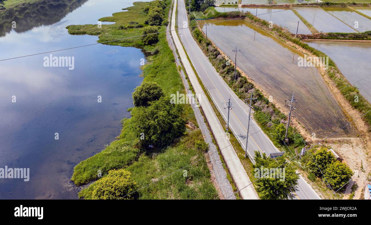 Luftaufnahme einer ländlichen Landschaft mit Straßen und Stromleitungen neben einem kleinen Fluss in Südkorea Stockfoto