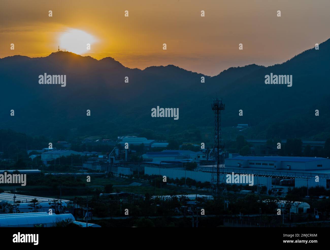 Sonnenuntergang über einem kleinen ländlichen Industriepark im Bergtal in Südkorea Stockfoto