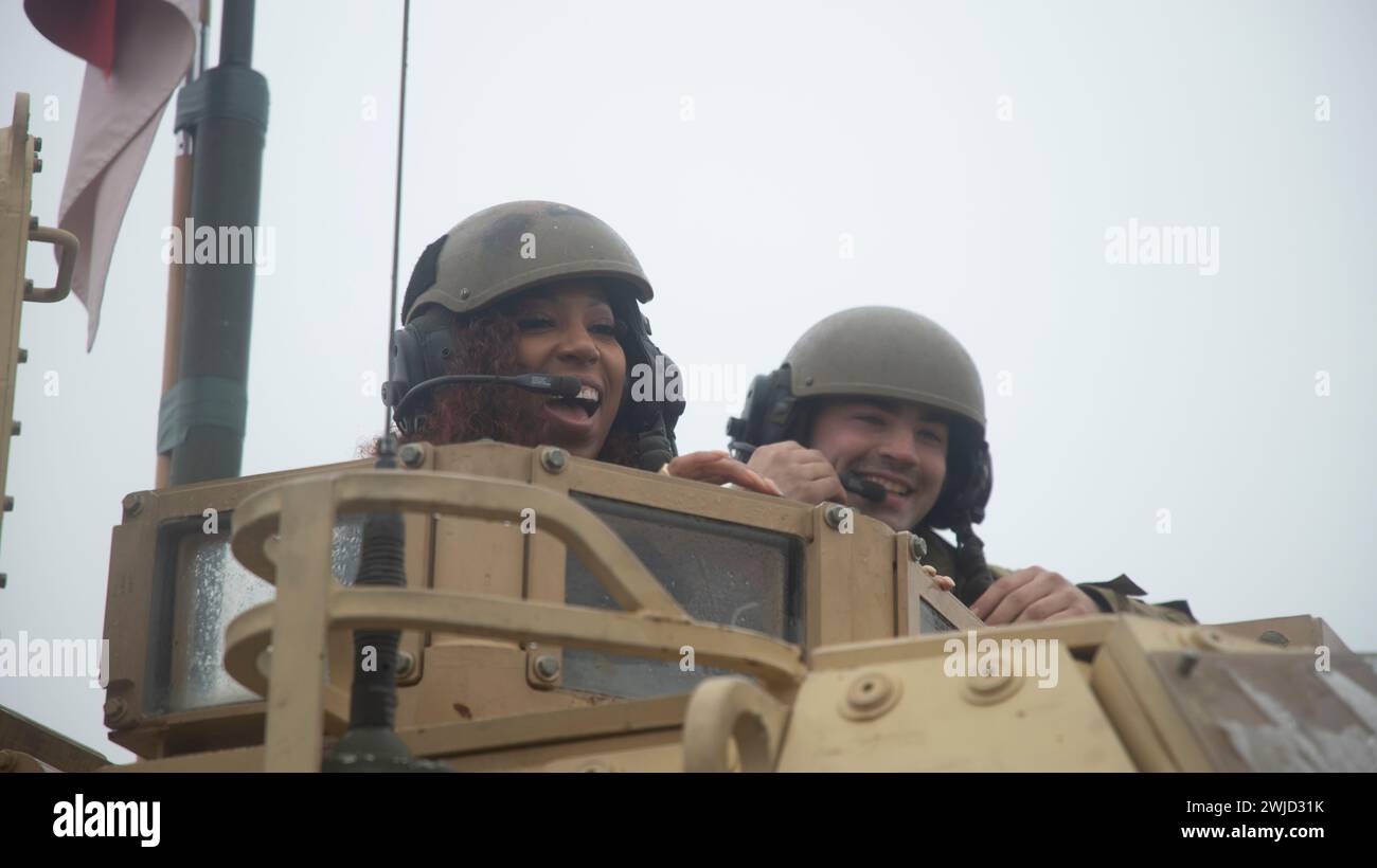 Drawsko Pomorskie, Polen. Februar 2024. Der Cheerleader Bre der Washington Commanders, der am 10. Februar 2024 im Drawsko Combat Training Center in Drawsko Pomorskie, Woiwodschaft Westpommern, Polen, in einem Kampfpanzer der US Army M1A2 Abrams mit der 1. Gepanzerten Division unterwegs ist. Die National Football League schloss sich als Teil der Pro Blitz 2024 mit der Armed Forces Entertainment zusammen. Quelle: SPC. Trevares Johnson/U.S. Army/Alamy Live News Stockfoto