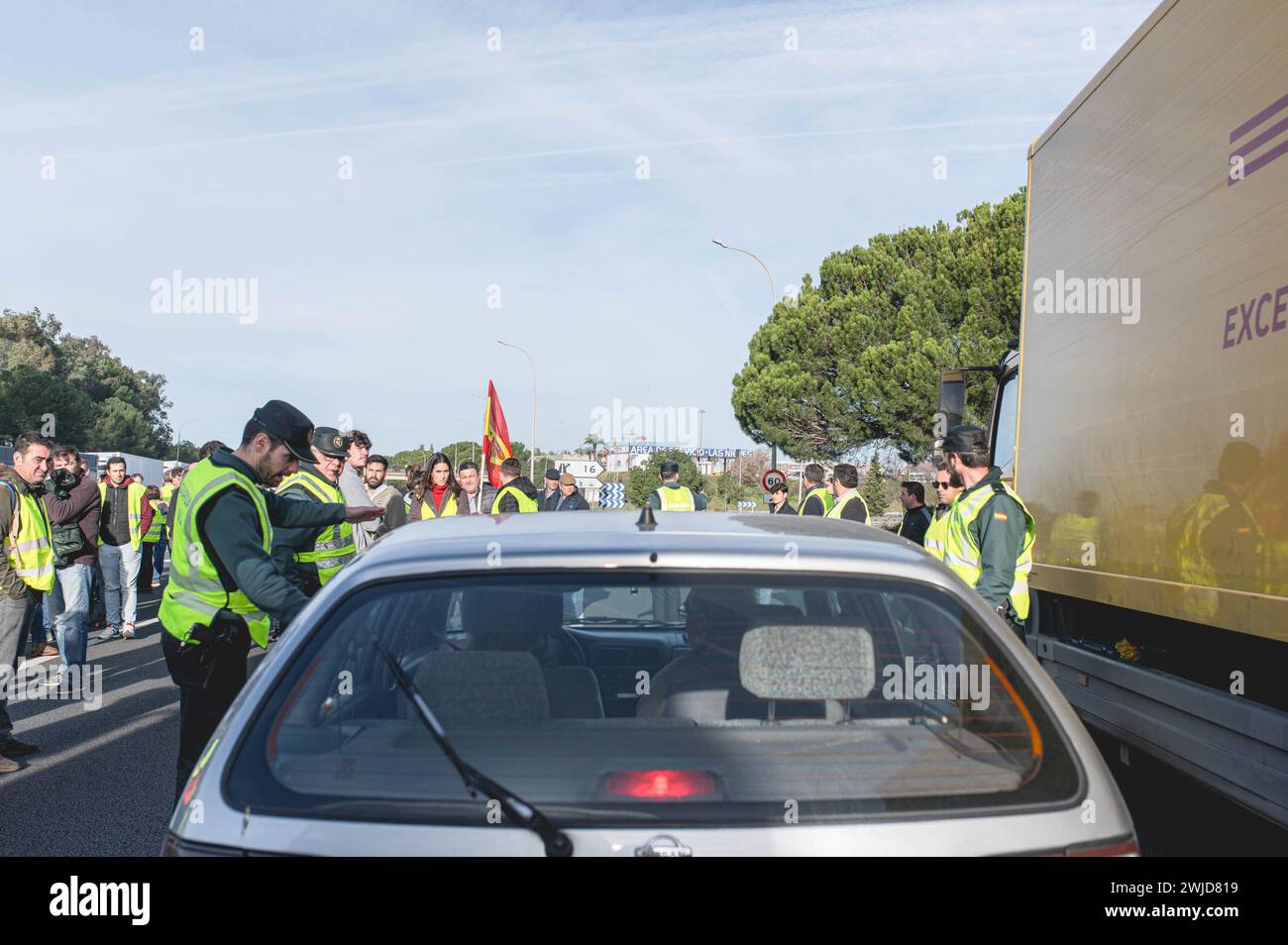 Die Zivilwache sah, wie sie einem Fahrer den Weg gab, die Streiklinie auf der Autobahn A49 zu verlassen. Andalusische Bauern haben alle Autobahnen blockiert, die nach Sevilla führen. Diese Proteste werden zum Teil von Gewerkschaften und landwirtschaftlichen Organisationen der extremen Rechten Spaniens gefördert, die die Probleme der Landwirte zum Ziel haben und dann Druck auf die Regierung ausüben. Diese Proteste finden seit dem 6. Februar in Spanien statt, als Reaktion auf die Proteste in Frankreich, wo sich die Landwirte über unlauteren Wettbewerb mit Produkten aus Drittländern, die europäische Agrarpolitik und die niedrigen Gewinne beklagen Stockfoto