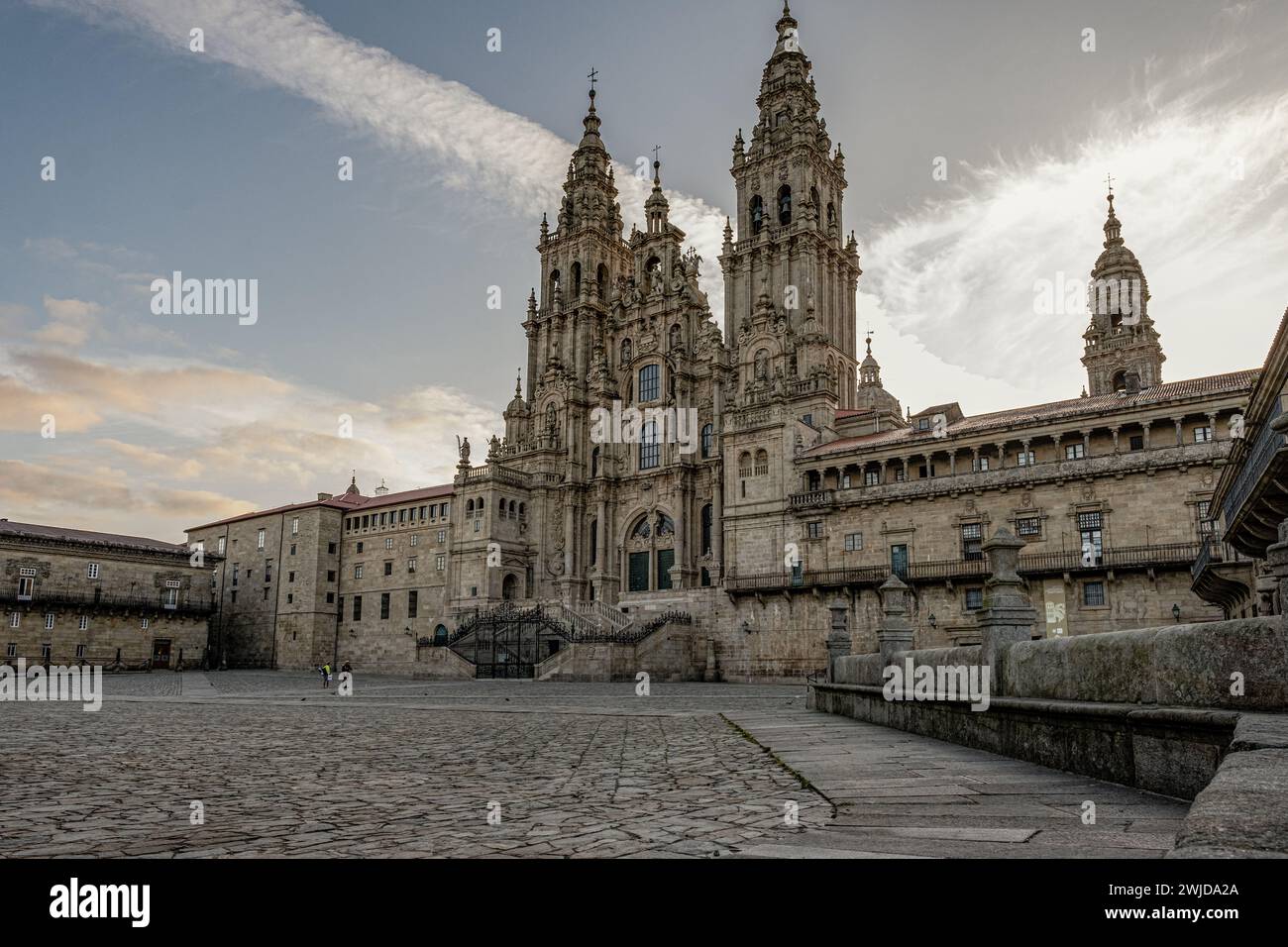 Santiago de Compostela, Galicien, Spanien: Zwei hingebungsvolle Pilger beenden ihren Spaziergang und betrachten die majestätische Kathedrale im noch leeren Praza do Obradoiro. Stockfoto