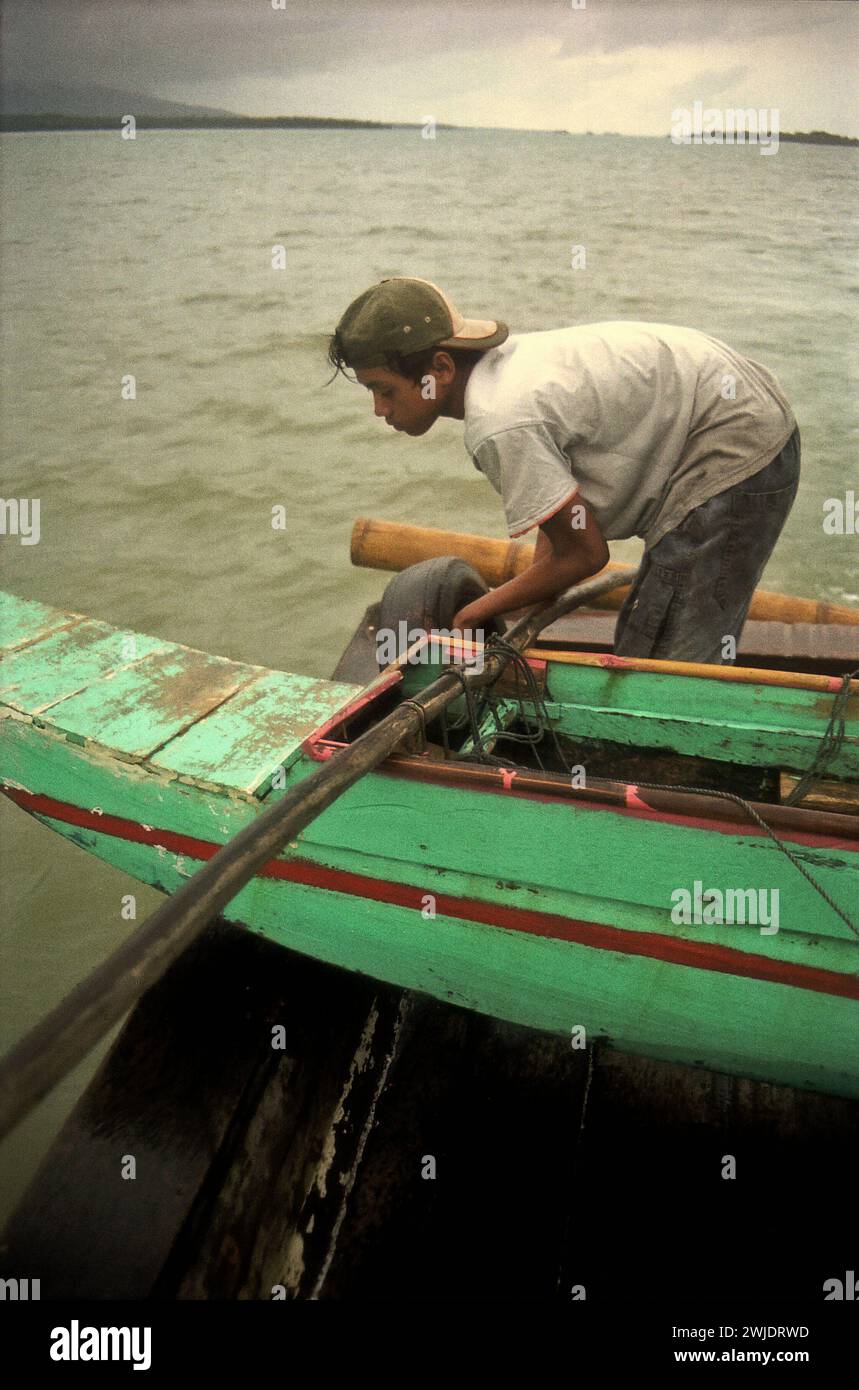 Eine Bootsbesatzung arbeitet auf einem gemieteten Boot, das bei schlechtem Wetter auf der Sunda-Straße segelt und nach der Verlassen der Insel Peucang, einem Teil des Ujung Kulon-Nationalparks in Pandeglang, Banten, Indonesien, in die Küstenstadt Sumur fährt. Stockfoto