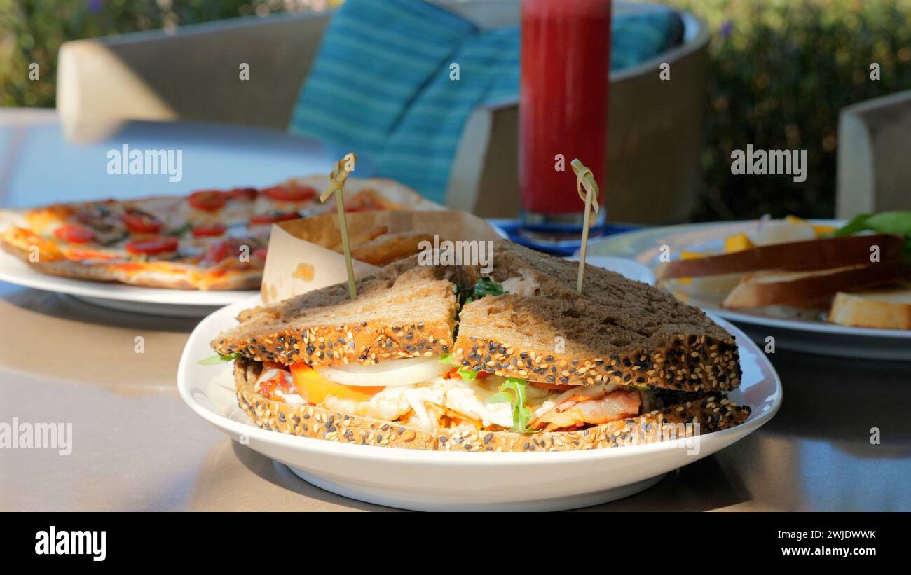 Auswahl an Speisen auf dem Tisch Sandwiches, Pizza und Teller Stockfoto