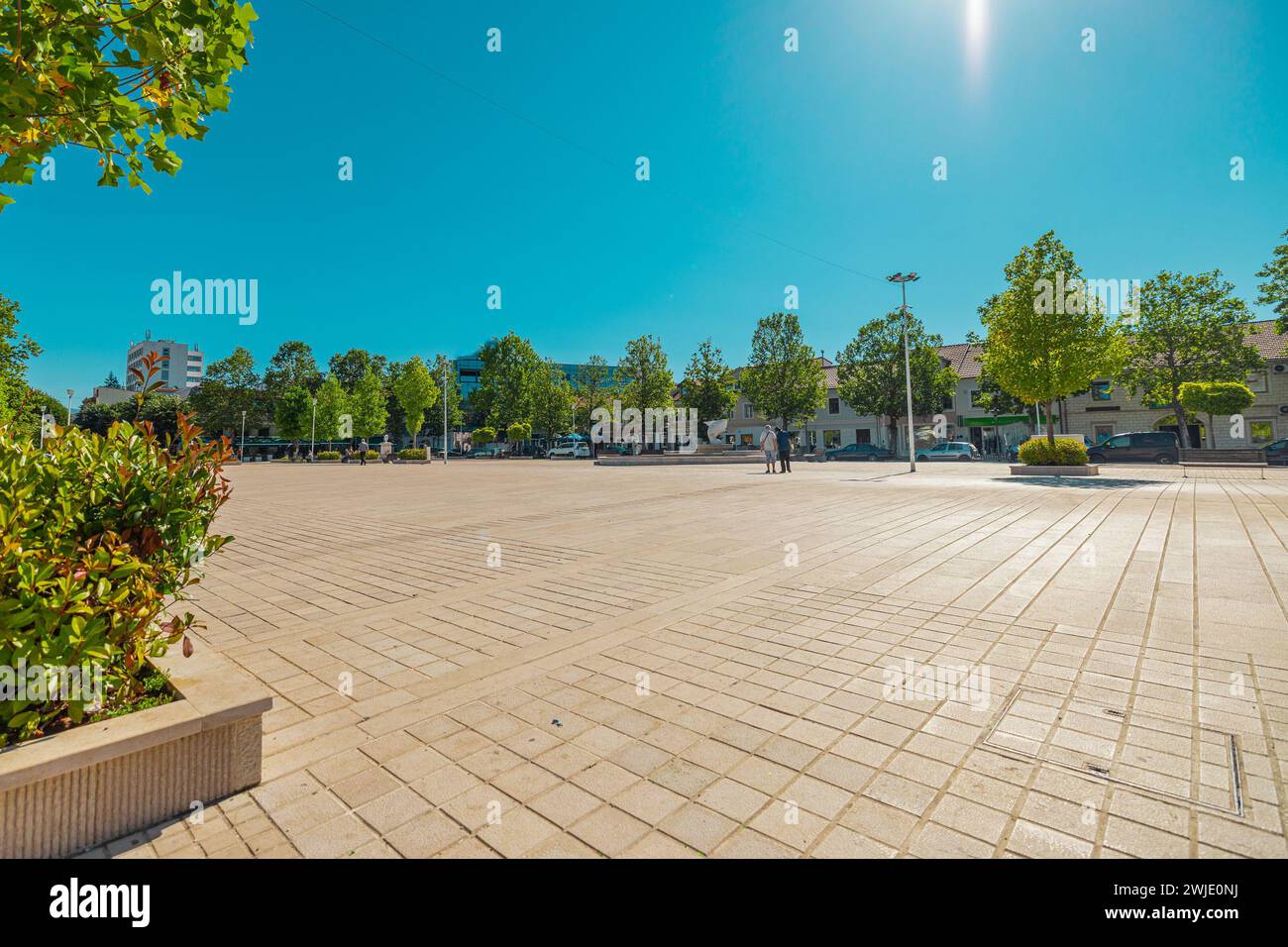 TRG Slobode oder Freiheitsplatz im Zentrum von Niksic, Montenegro an einem sonnigen Tag. Flaches Freigelände im Zentrum einer Stadt, umgeben von Bäumen und Fol Stockfoto