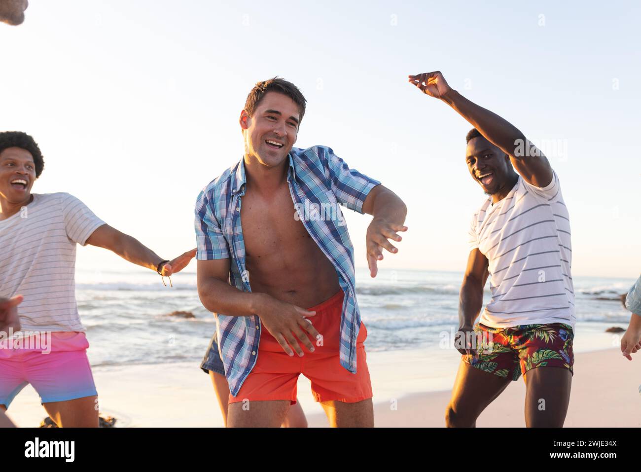 Junge Männer genießen einen lebendigen Moment am Strand Stockfoto
