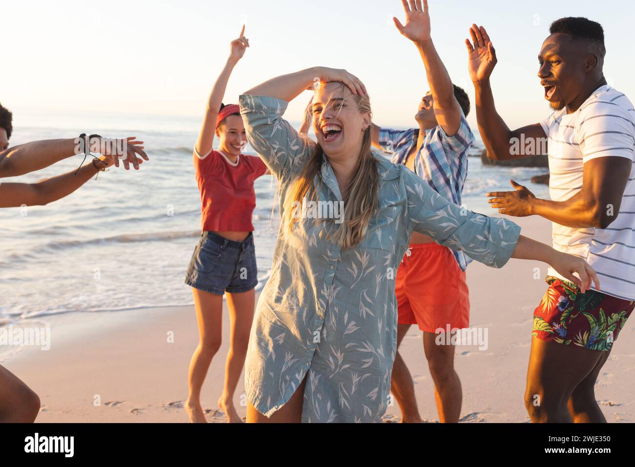 Eine Gruppe von Freunden genießt eine Strandparty bei Sonnenuntergang Stockfoto