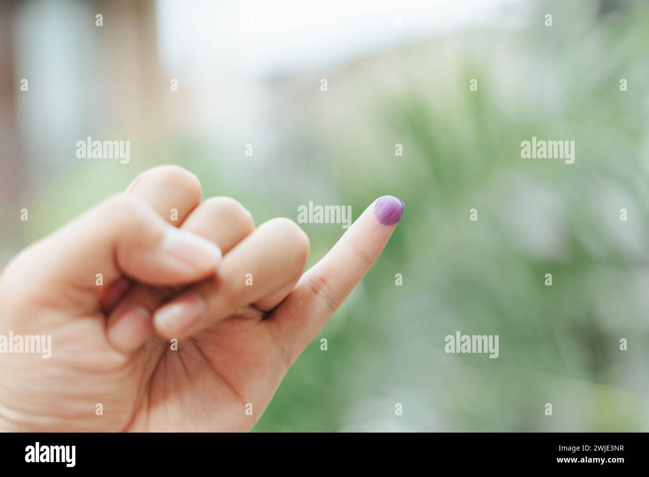 Ein indonesischer Mann zeigt einen kleinen Finger, der mit Tinte bedeckt ist, nachdem er die Wahl oder Pemilu abgegeben hat Stockfoto