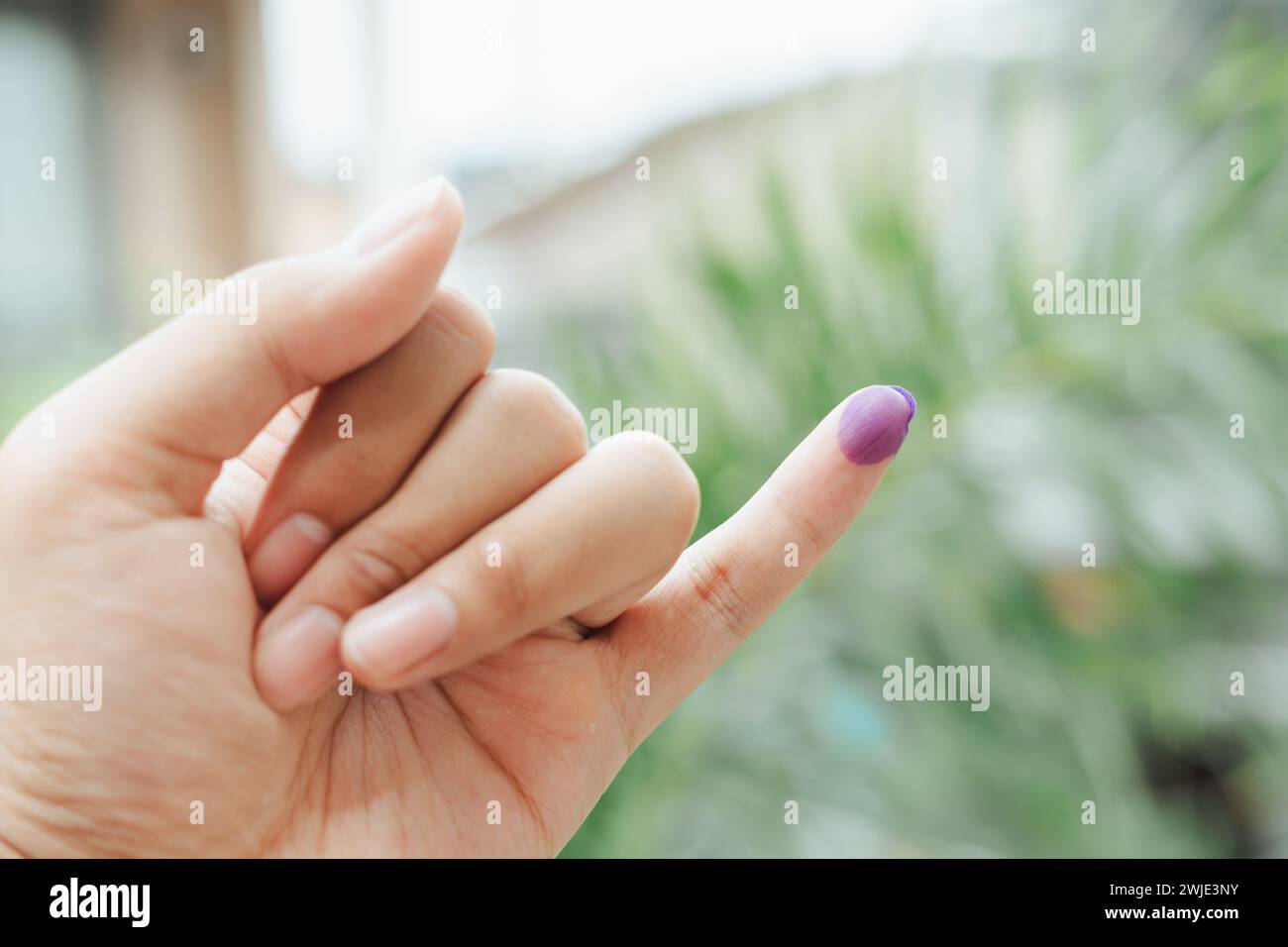Ein indonesischer Mann zeigt einen kleinen Finger, der mit Tinte bedeckt ist, nachdem er die Wahl oder Pemilu abgegeben hat Stockfoto