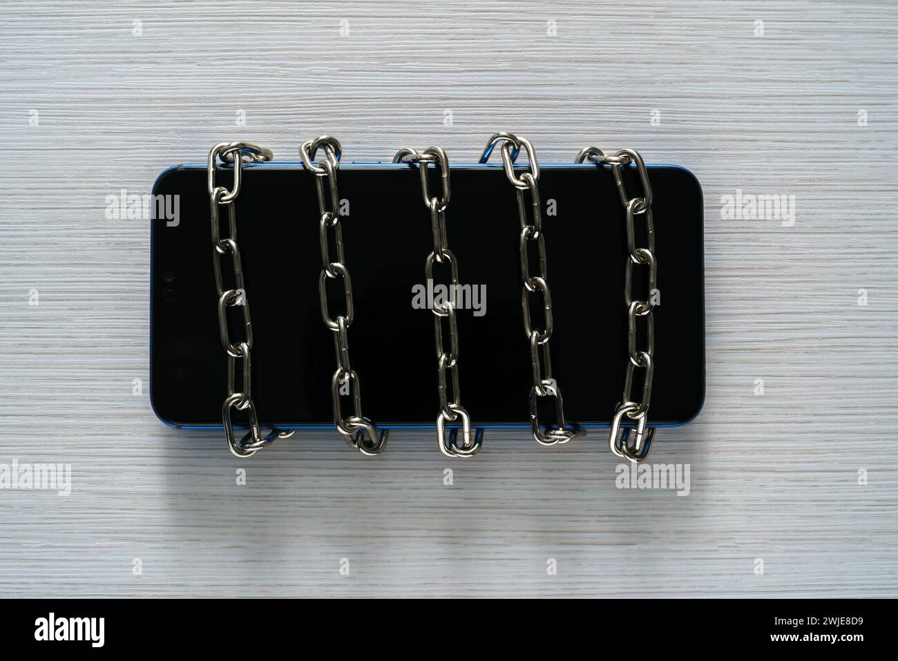 Kette auf einem Mobiltelefon. Begriff der Zeitbegrenzung in sozialen Netzwerken, Abhängigkeit von IT oder digitaler Detox. Stockfoto