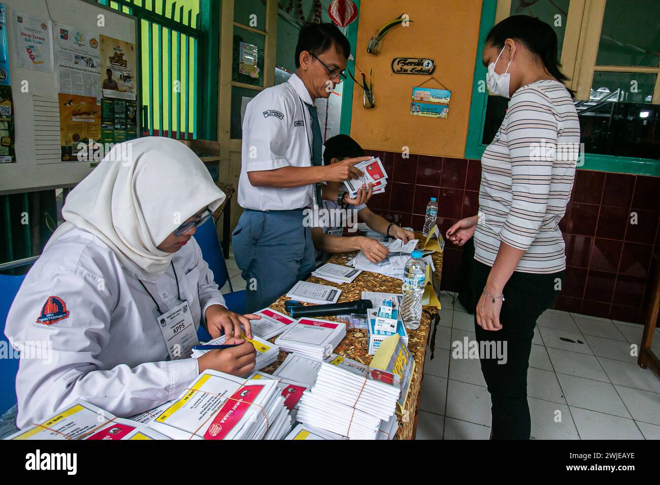 Beamte der Personalwahl trugen Schuluniformen in einem Wahllokal bei den Parlamentswahlen in Bogor, Indonesien, am 14. Februar 2024 Stockfoto