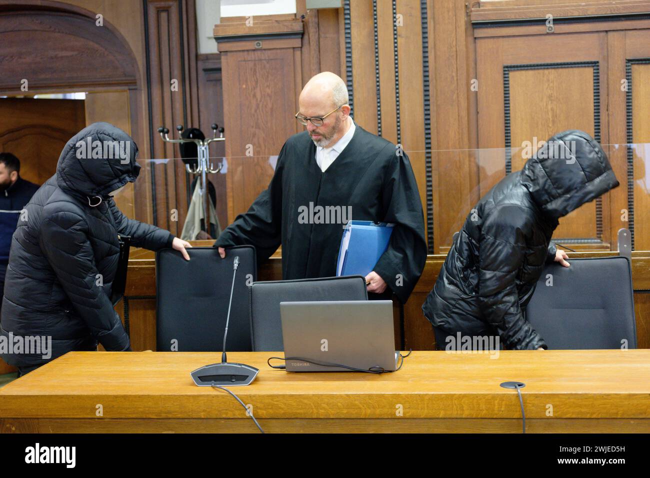 15. Februar 2024, Nordrhein-Westfalen, Mönchengladbach: Die beiden Angeklagten und der Rechtsanwalt Lutz Adam (M) betreten den Gerichtssaal vor Beginn des Prozesses. Ein 13-jähriger Diabetesschüler war auf einer Schulreise gestorben, die sie beaufsichtigten. Die Staatsanwaltschaft wirft den Frauen vor, sich nicht explizit über die bereits bestehenden Bedingungen der Teilnehmer zu erkundigen. Insgesamt hatten vier Lehrer die Reise begleitet. Foto: Henning Kaiser/dpa Stockfoto