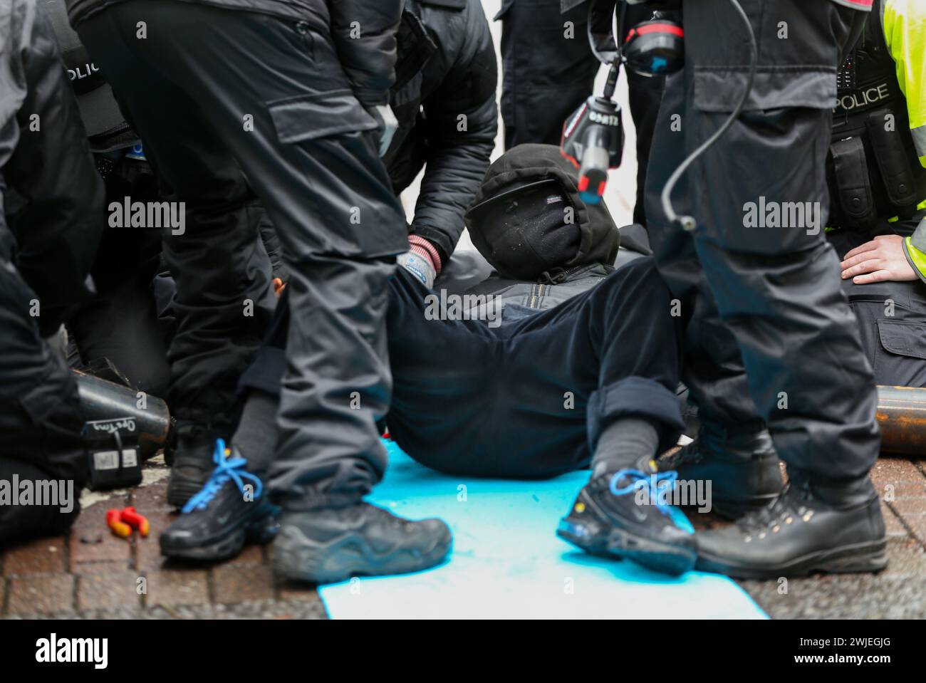 Spezialpolizisten aus dem Schnittteam entfernen den zentralen Demonstranten während des Protestes aus ihrer Sperre. Unterstützer der Palästinensischen Aktion blockieren den einzigen Fahrzeugzugang zur israelischen Verteidigungsfirma, dem Geschäft von Elbit Systems in Aztec West, Bristol. Sie argumentieren, dass die von Elbit in Großbritannien hergestellten Waffen von der israelischen Verteidigungsstreitkräfte gegen Palästinenser in Gaza und anderswo eingesetzt werden. Bei den israelischen Bombenanschlägen im Gazastreifen sind seit Oktober 2023 mehr als 30.000 Palästinenser ums Leben gekommen. Die Palästinensische Aktion ist entschlossen, Elbit und ihre Partnerunternehmen unerbittlich ins Visier zu nehmen Stockfoto