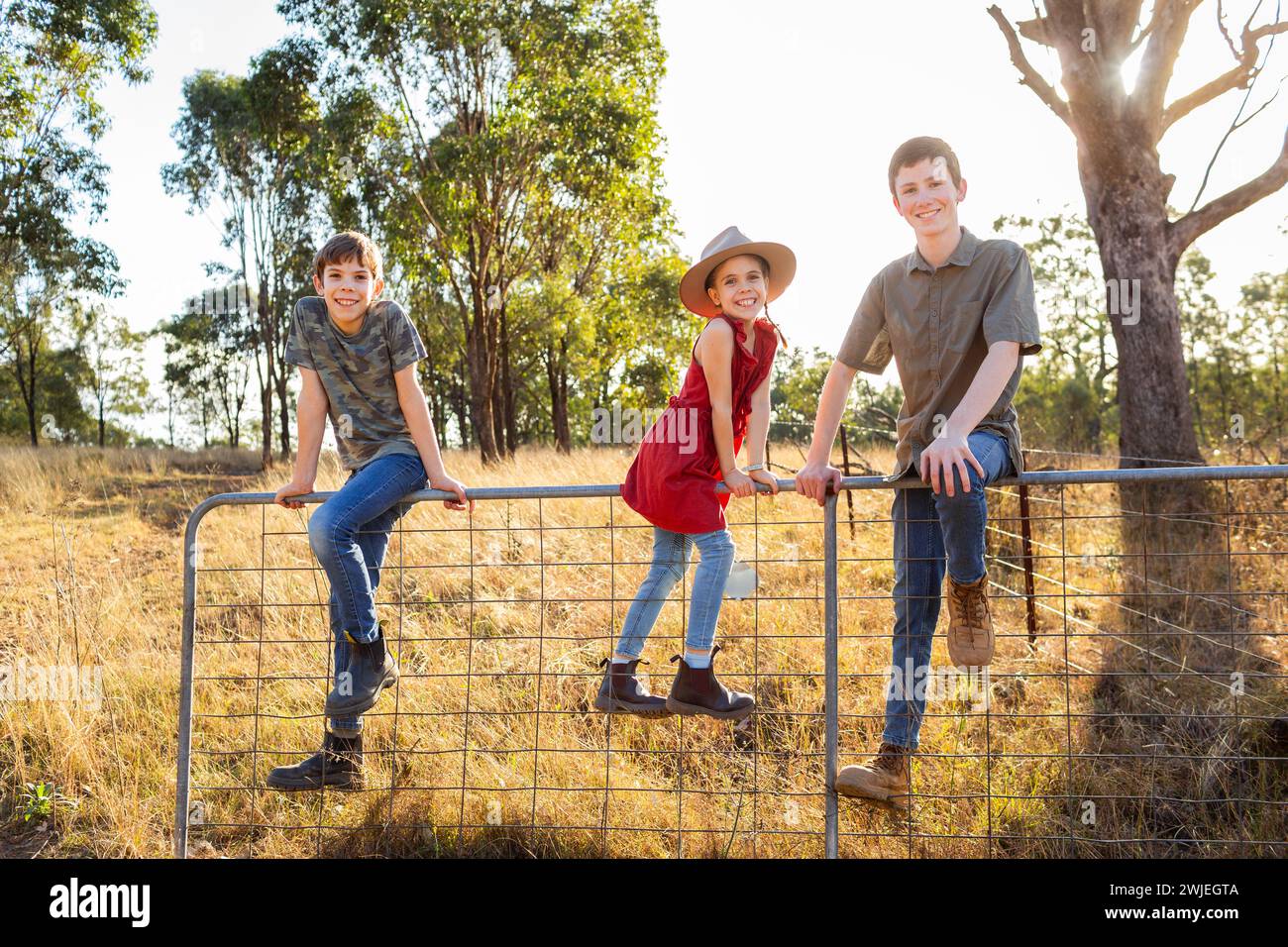 Drei Landkinder im australischen Fahrerlager sitzen am Tor Stockfoto