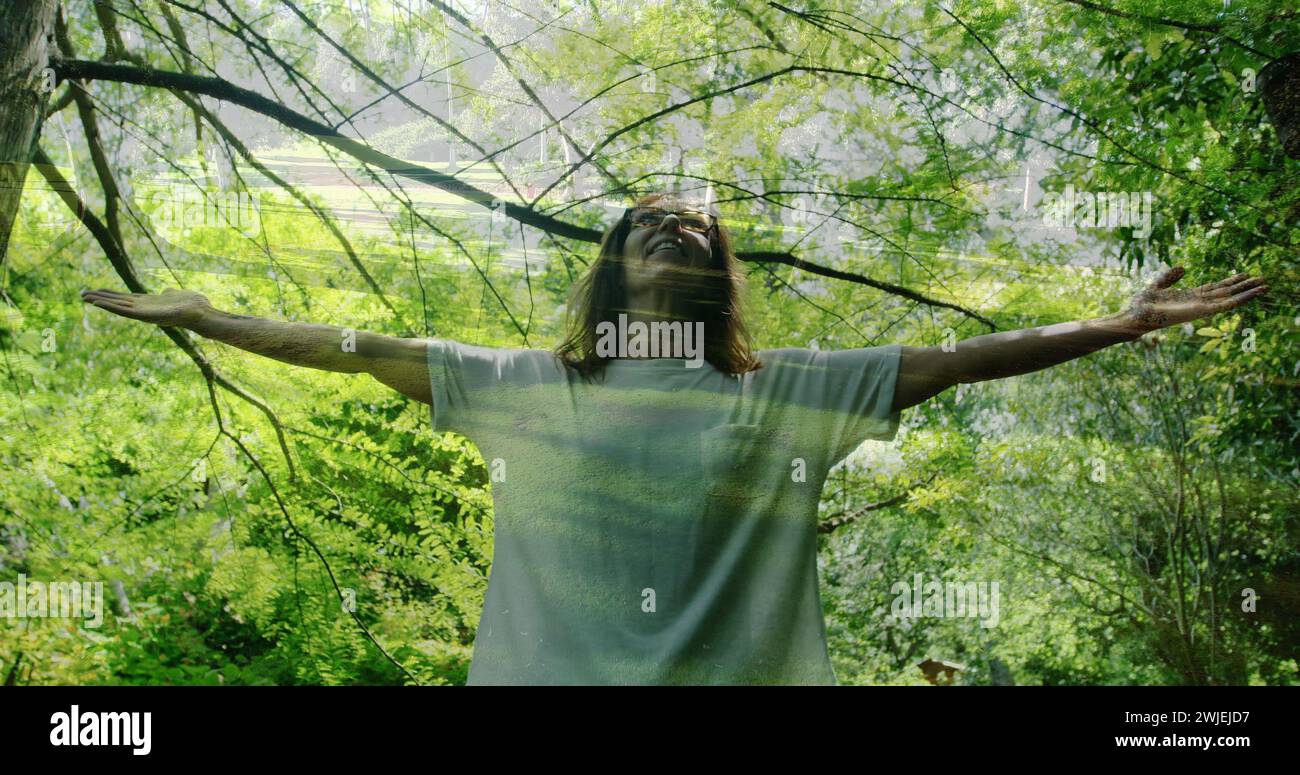 Frau mit weit offenen Armen im Wald Stockfoto