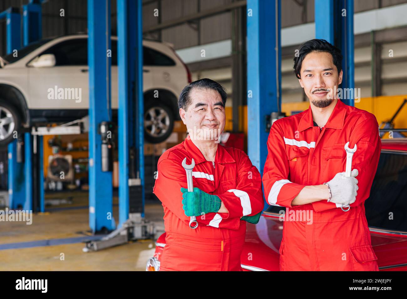 Porträt asiatische japanische männliche Mechaniker Arbeiter Team in Auto Service Werkstatt Auto Wartung Center ersetzen Fix Auto Motor Teil Stockfoto