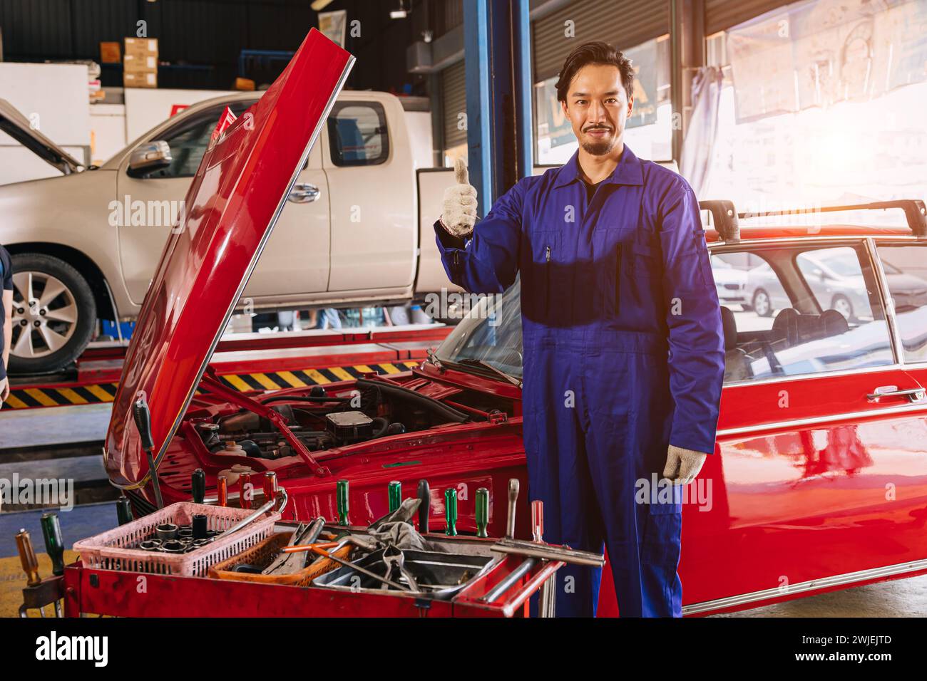 Porträt Asiatisch Japanisch männlicher Mechaniker Arbeiter Porträt in Auto Service Werkstatt Auto Wartungszentrum ersetzen Fix Auto Motor Teil Stockfoto