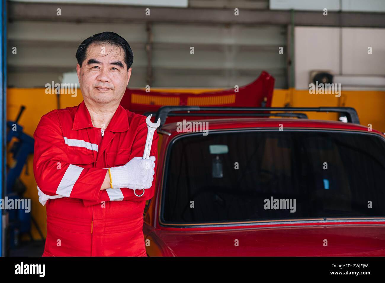 Glückliche Senior professionelle asiatische männliche Mechaniker Garage Arbeiter glückliche Arbeit ersetzen Wartung Auto Service in der Autowerkstatt Stockfoto