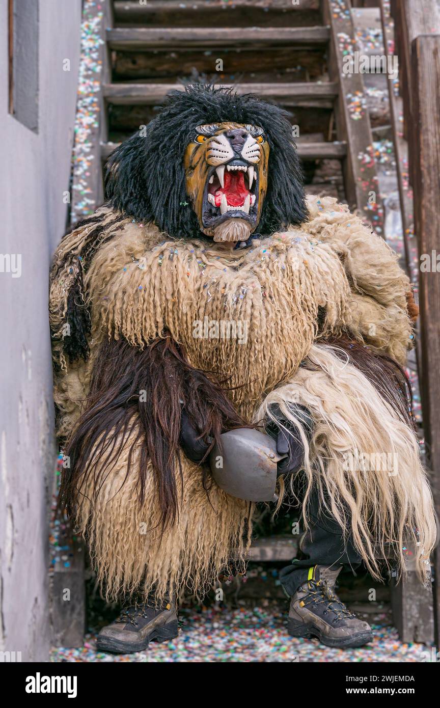 Nachtschwärmer mit Holzmaske und Karnevalskostüm. Evolene, Kanton Wallis, Schweiz. Stockfoto