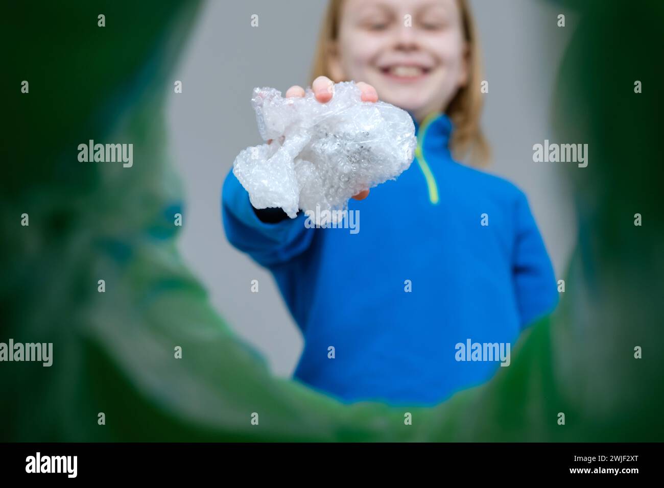 Aufrollbare Kunststoffpolsterfolie mit niedriger Sichtweite in einem Abfalleimer, Recycling- und Abfallsortierkonzept. Stockfoto