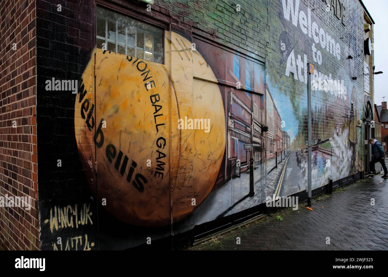 Atherstone, Großbritannien. Februar 2024. Eine Plakatwand begrüßt Besucher in Atherstone mit einem Wandgemälde, für die die Stadt berühmt ist, einschließlich des Ballspiels. Die Spieler kommen zusammen, um das Atherstone Ball Game zu spielen. Das Spiel 2024 ist das 824. Und es geht auf das Jahr 1199 zurück. Spieler kämpfen auf der Straße um einen übergroßen Ball. Wer den Ball nach zwei Stunden in der Hand hat, gewinnt. Das Spiel ehrt ein Spiel zwischen Leicestershire und Warwickshire im Jahr 1199, bei dem die Teams eine Tasche Gold als Ball verwendeten. Quelle: SOPA Images Limited/Alamy Live News Stockfoto