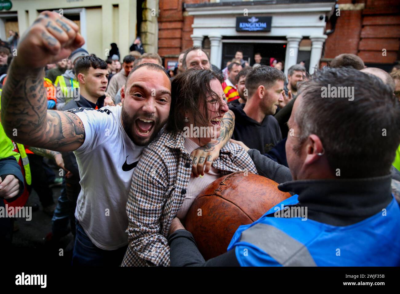 Atherstone, Großbritannien. Februar 2024. Die Spieler feiern, dass sie nach einer frühen Phase des Spiels mit dem Ball anfangen. Die Spieler kommen zusammen, um das Atherstone Ball Game zu spielen. Das Spiel 2024 ist das 824. Und es geht auf das Jahr 1199 zurück. Spieler kämpfen auf der Straße um einen übergroßen Ball. Wer den Ball nach zwei Stunden in der Hand hat, gewinnt. Das Spiel ehrt ein Spiel zwischen Leicestershire und Warwickshire im Jahr 1199, bei dem die Teams eine Tasche Gold als Ball verwendeten. Quelle: SOPA Images Limited/Alamy Live News Stockfoto