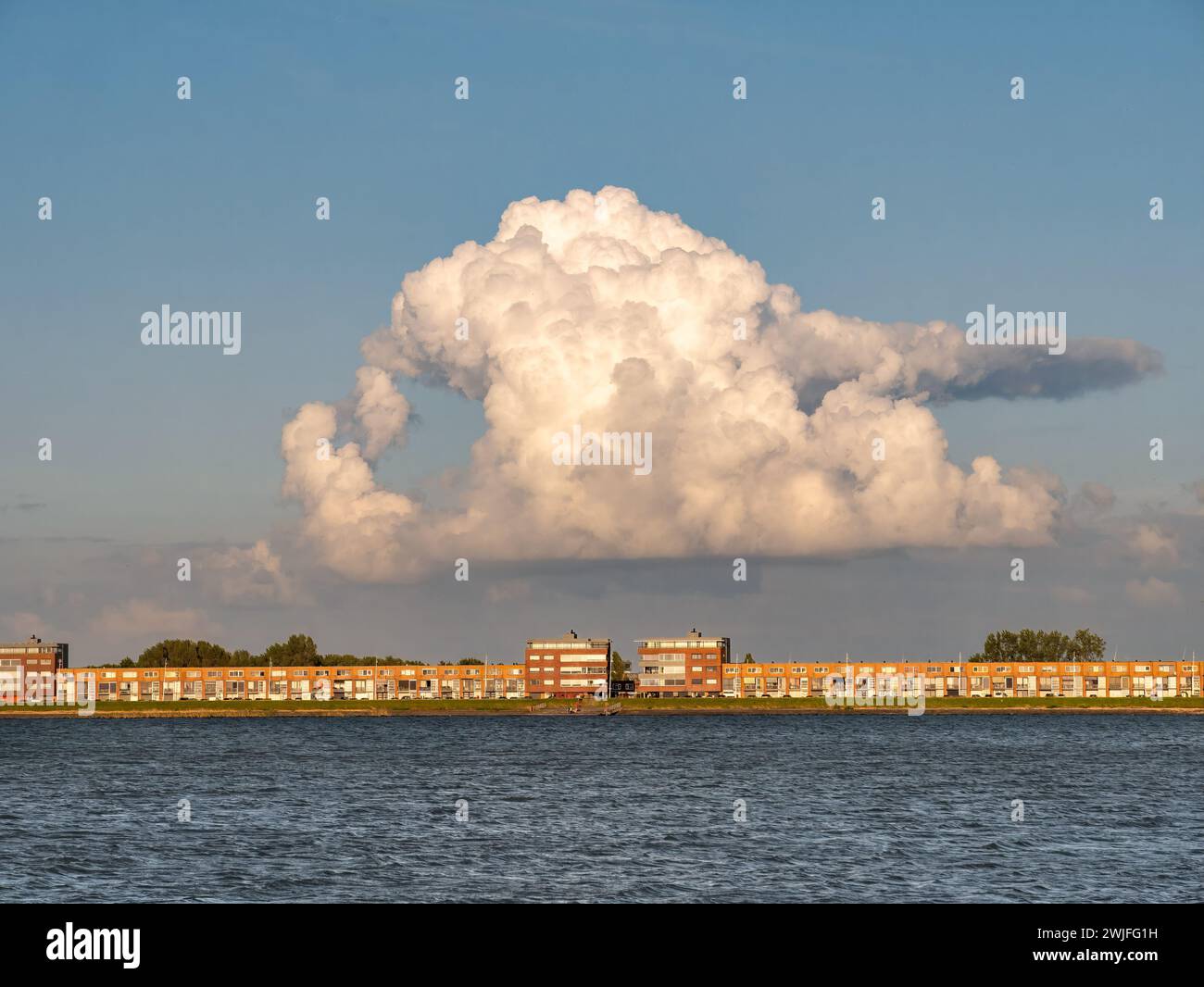 Riesige wachsende Kumulonimbuswolke über den Wohngebäuden von IJsselmeerdijk in Lelystad, Niederlande Stockfoto