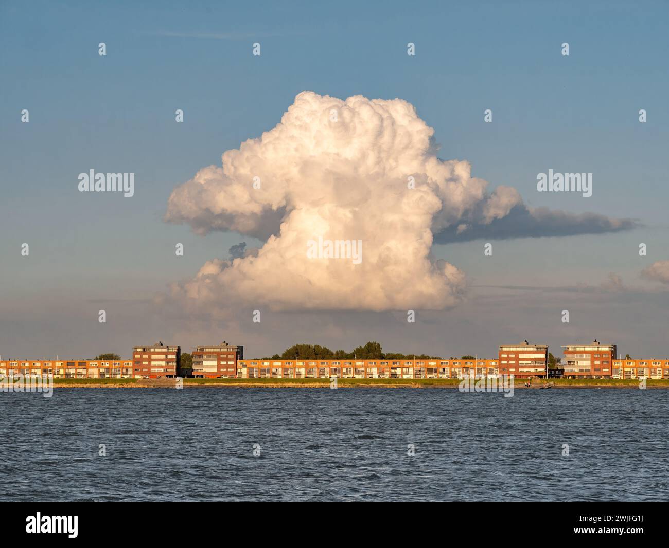 Riesige wachsende Kumulonimbuswolke über den Wohngebäuden von IJsselmeerdijk in Lelystad, Niederlande Stockfoto
