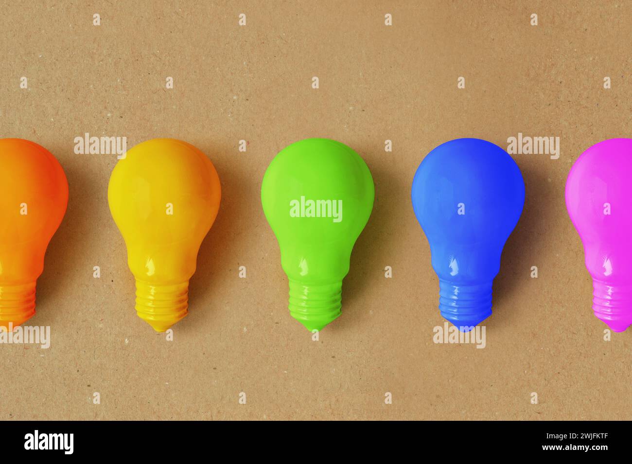 Glühbirnen in verschiedenen Farben auf Recyclingpapierhintergrund - Vorstellung von Kreativität und divergentem Denken Stockfoto