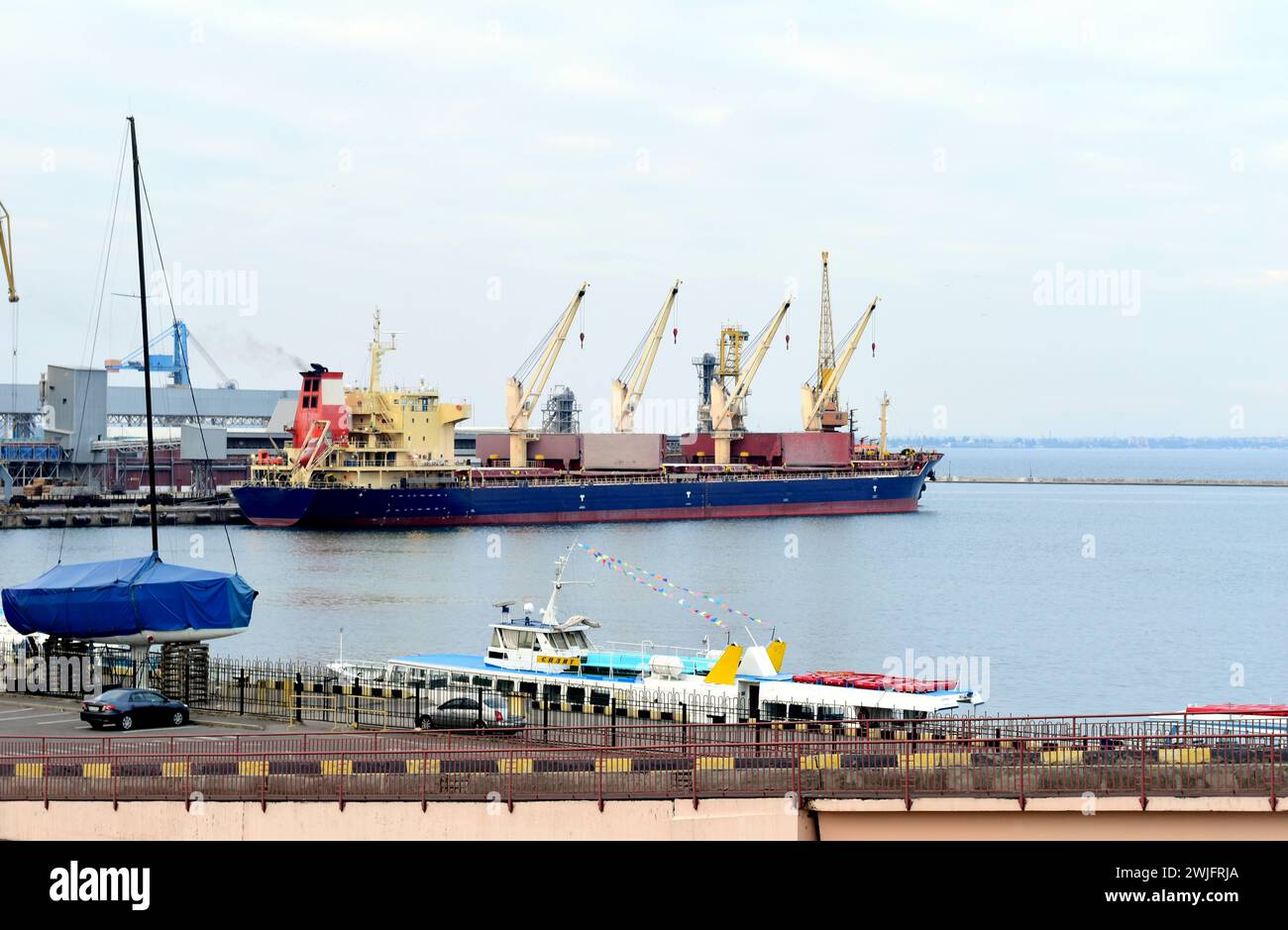 Frachtschiff mit Containern am Pier, wo sich ein Hafenkran befindet. Hochwertige Fotos Stockfoto