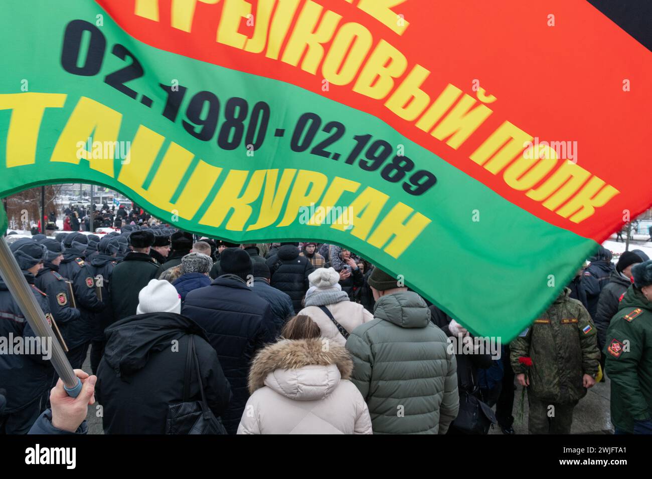 St. Petersburg, Russland. Februar 2024. Ein Mann hält die Flagge eines motorisierten Gewehrregiments bei einer Veranstaltung, die dem 35. Jahrestag des Rückzugs der sowjetischen Truppen aus Afghanistan gewidmet ist. Russland feiert den Tag des vollständigen Rückzugs der sowjetischen Truppen aus Afghanistan. Der Krieg in Afghanistan dauerte von 1979 bis 1989, nach offiziellen Angaben starben mehr als 15.000 sowjetische Soldaten. (Foto: Andrei Bok/SOPA Images/SIPA USA) Credit: SIPA USA/Alamy Live News Stockfoto