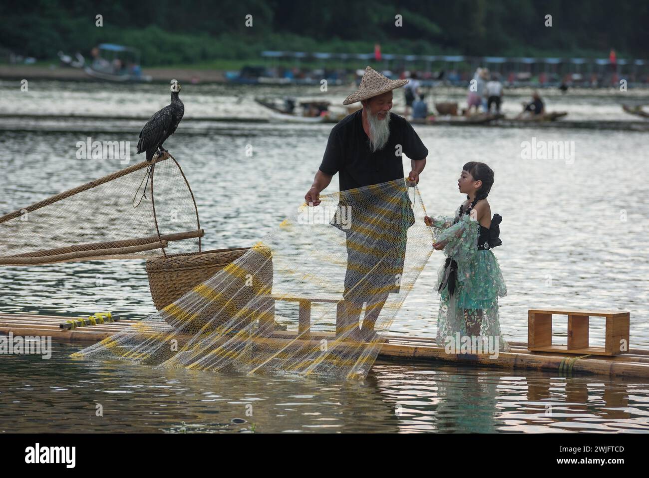 Ein kleines Mädchen macht Fotos mit dem Fischer. Das Fotografieren mit dem Fischer ist ein Touristenprojekt, das Touristen anzieht. Stockfoto