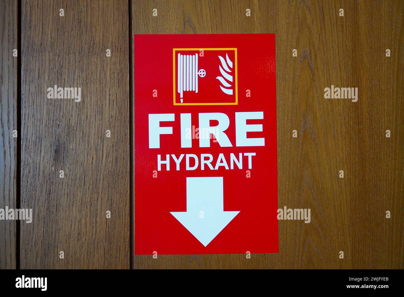 Roter Aufkleber mit Feuerlöschschild an Holzwand Stockfoto