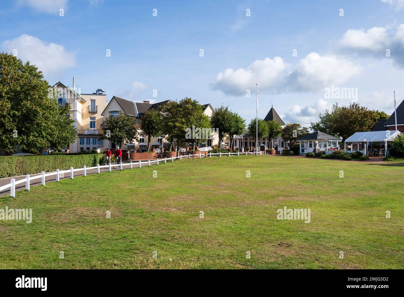 Ortskern von Norddorf auf der Insel Amrum eine grüne Wiese und das Gebäude des Hotels Hüttmann im Sonnenschein *** das Zentrum von Norddorf auf der Insel Amrum eine grüne Wiese und das Gebäude des Hotels Hüttmann im Sonnenschein Stockfoto