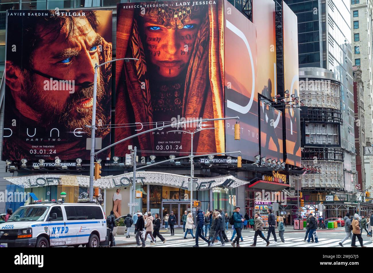 Horden von Menschen überqueren die West 42nd Street unter Werbung für die Warner Bros PicturesÕ ÒDune: Teil des TwoÓ Films am Times Square in New York am Sonntag, 11. Februar 2024. Der Film soll am 1. März veröffentlicht werden. (© Richard B. Levine) Stockfoto