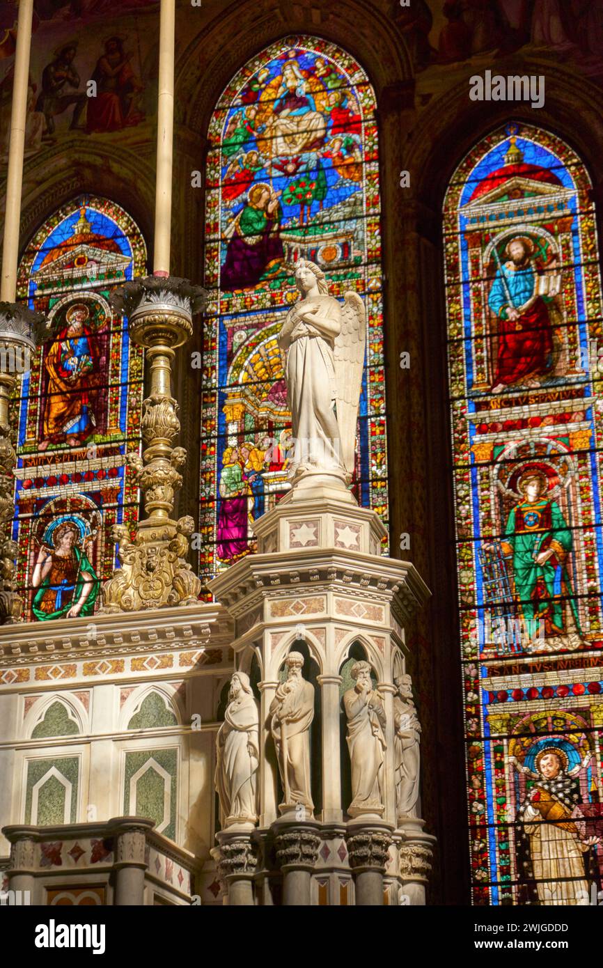 Hoher Altar mit Marmorengel, Kerzen und Buntglas im Sonnenschein, Kirche Santa Maria Novella, Florenz, Italien Stockfoto