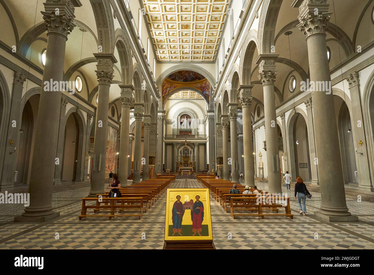 Inneres der Basilika San Lorenzo, Florenz, Italien, entworfen von Filippo Brunelleschi, mit einem Gemälde der Heiligen Cosmas und des Heiligen Damian im Vordergrund Stockfoto