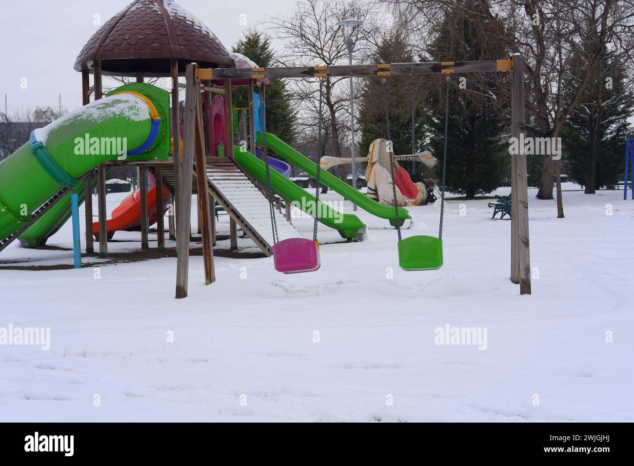 Kinderspielplatz im öffentlichen Park mit Schnee bedeckt Stockfoto