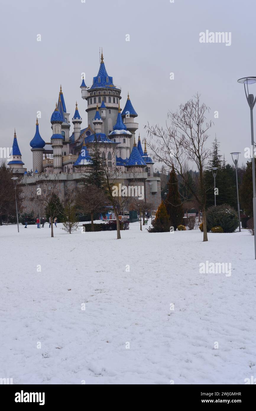 Vintage-blaues Schloss im Sazova Park Eskisehir Türkei. Märchenschloss im Winter unter Schnee. Das Schloss ist hinter den Büschen zu sehen Stockfoto