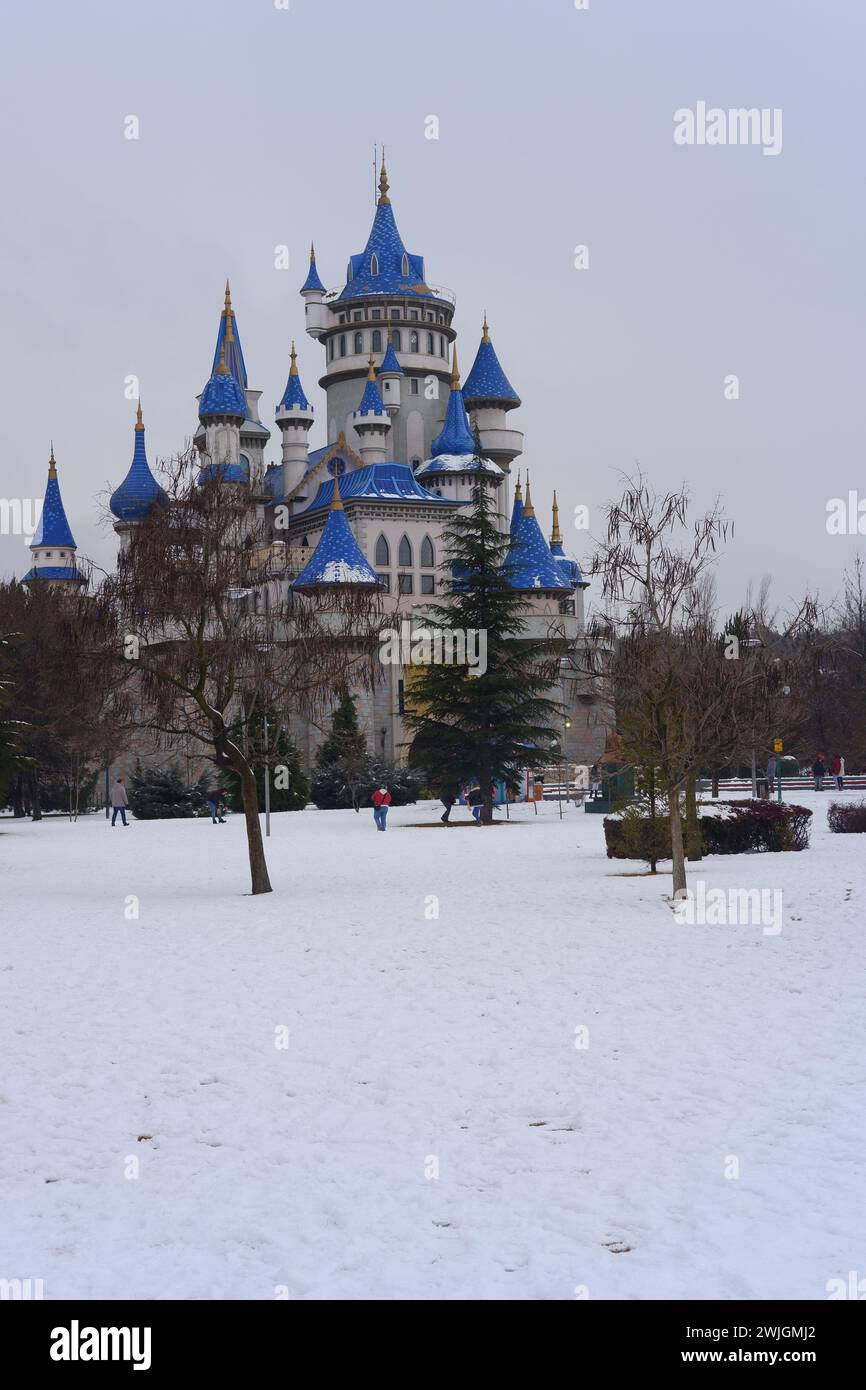 Vintage-blaues Schloss im Sazova Park Eskisehir Türkei. Märchenschloss im Winter unter Schnee. Das Schloss ist hinter den Büschen zu sehen Stockfoto