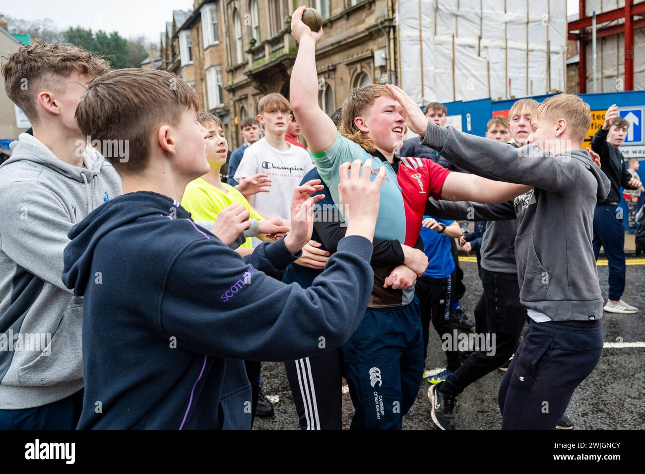 Jugendliche nehmen an der jährlichen Handba in der schottischen Grenzstadt Jedburgh Teil. Traditionell wurde das erste Spiel mit dem Kopf eines Engländers gespielt, die Bänder auf dem Ball symbolisieren sein Haar. Die Teams (Uppies und Doonies) werden nach ihrem Wohnort ausgewählt – Uppies sind die im Süden geborenen und Doonies im Norden des Market Cross. Quelle: Euan Cherry Stockfoto