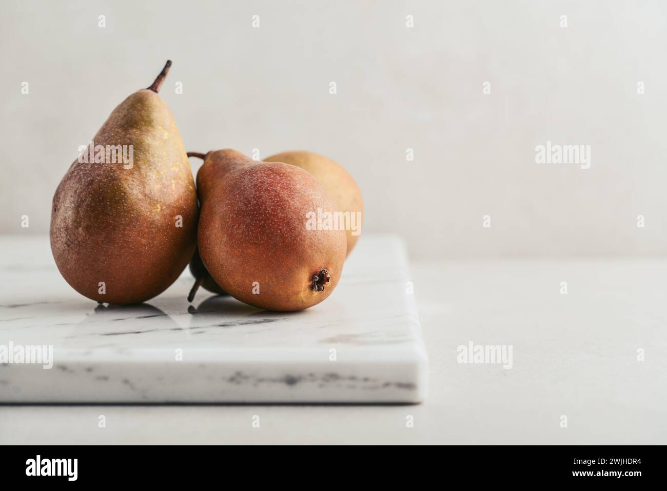 Konferenzbirnen auf Marmor Schneidebrett Nahaufnahme Stockfoto
