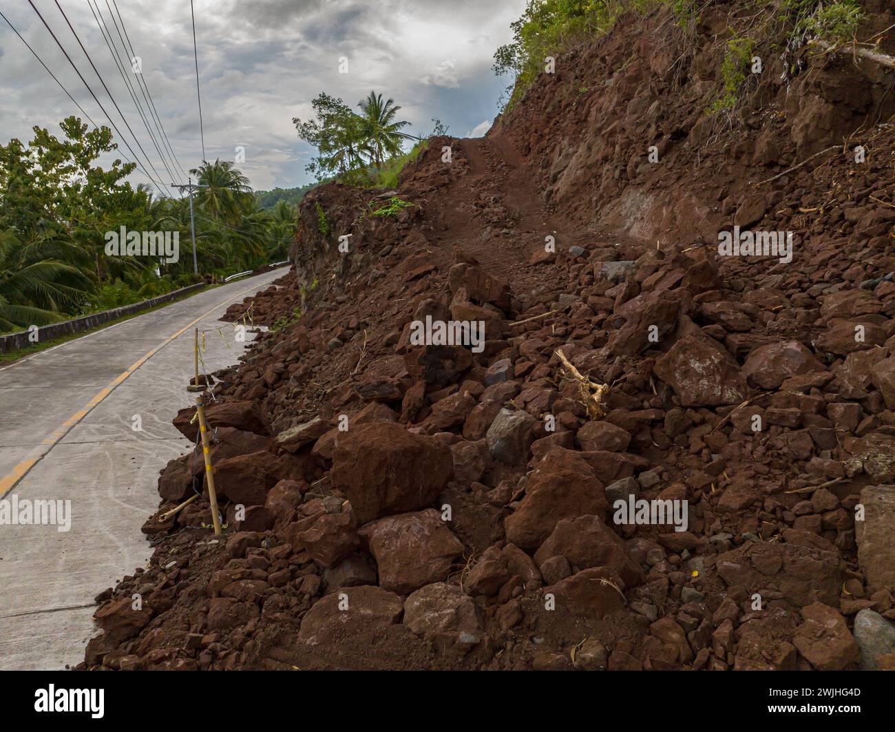 Bergerdrutsch aufgrund starker Regenfälle. Schlamm und Felsen rechts auf der Straße. Philippinen. Stockfoto