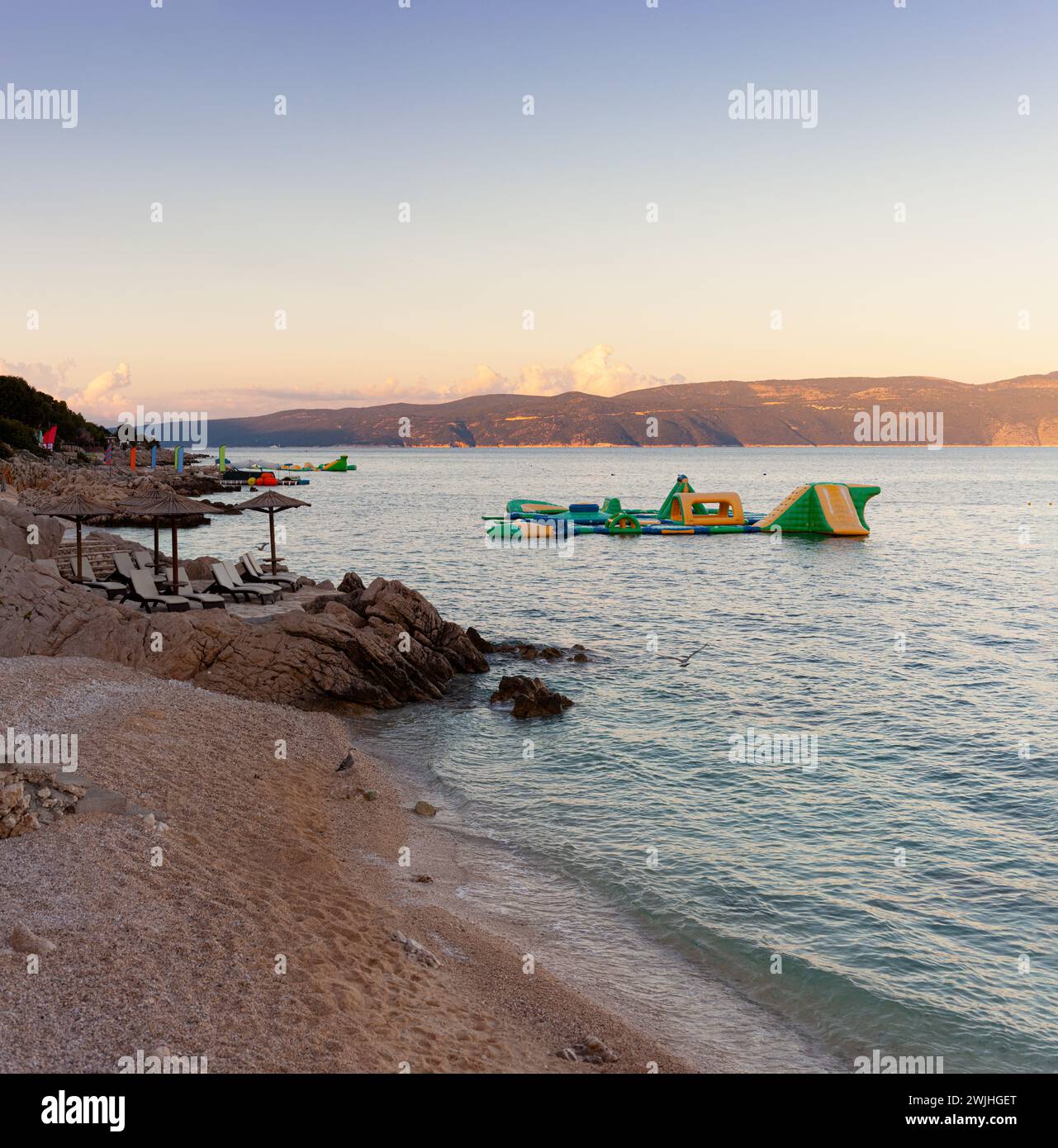 Strohschirme am Strand von Rabac, kroatischer Ferienort an der Kvarner Bucht, direkt südöstlich von Labin in Istrien. Lange ein kleiner Fischerhafen, Rabac Stockfoto